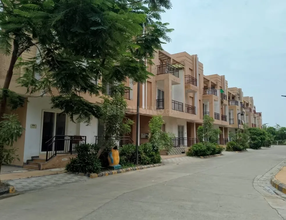 Ajnara Panorama Phase 2 Villas — Row of modern villas with balconies and a paved road with trees in an Indian residential project