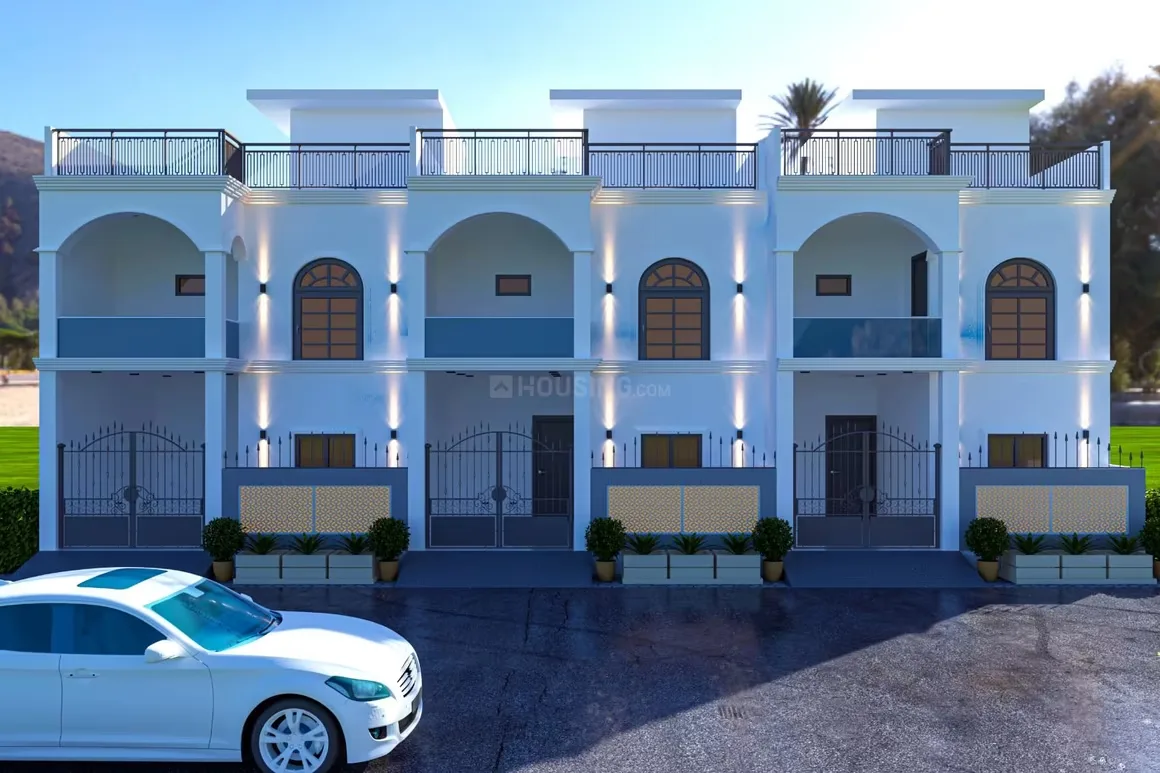 Essential Lotus Green 2 — A white car parked in front of a row of three contemporary villas with arched windows and balconies.