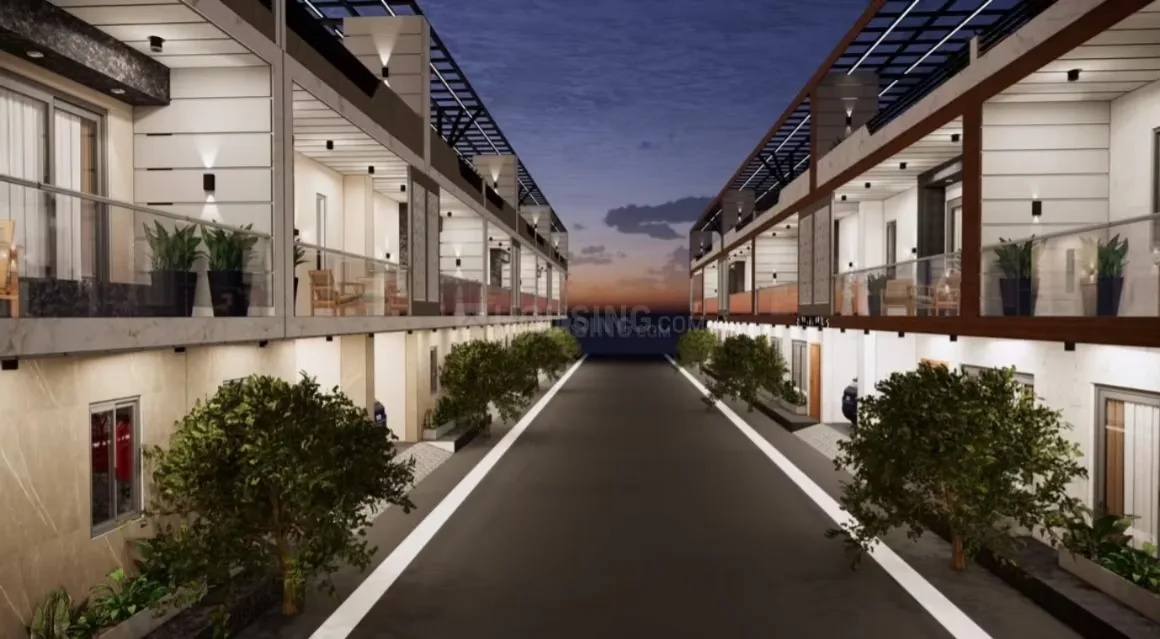 Green Vatika Luxurious Villas — Night view of a street between two rows of modern villas with balconies, potted plants, and glowing lights.