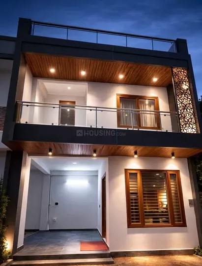 Mudgal Ved Villa — A modern three-story villa with white walls, dark gray trim, and warm wooden accents under a dark evening sky.