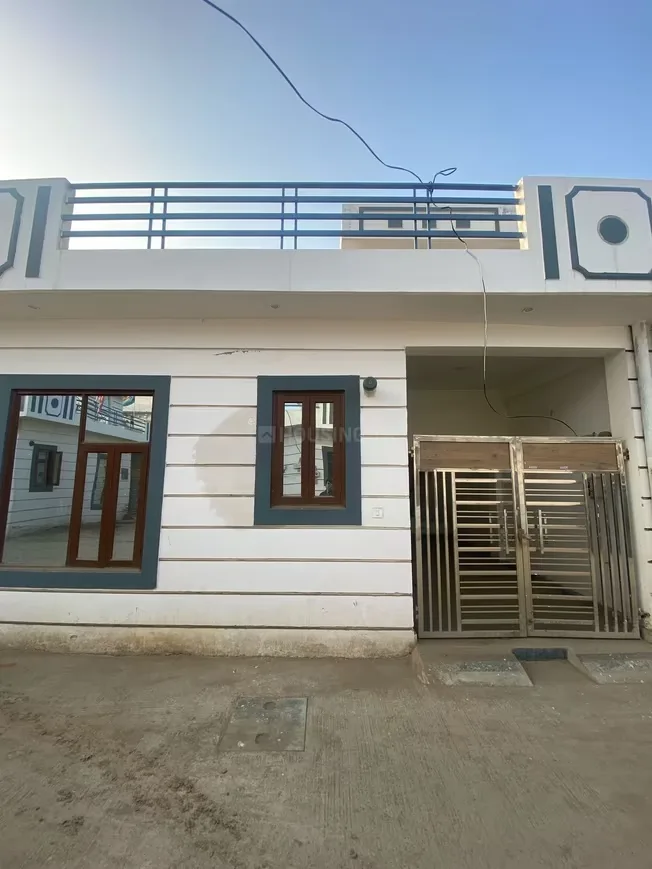 Shivi Ashok Gokul Villa — Front view of a white residential villa with grey accents, a small balcony with railings, and a metal gate.