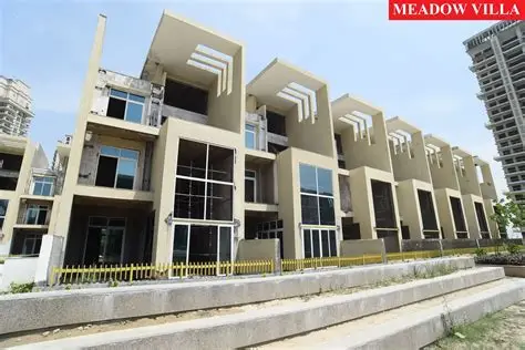 Mahagun Meadows three-storey villa row in Sector 150 Noida Expressway with stone-clad façades and cantilevered upper floors.
