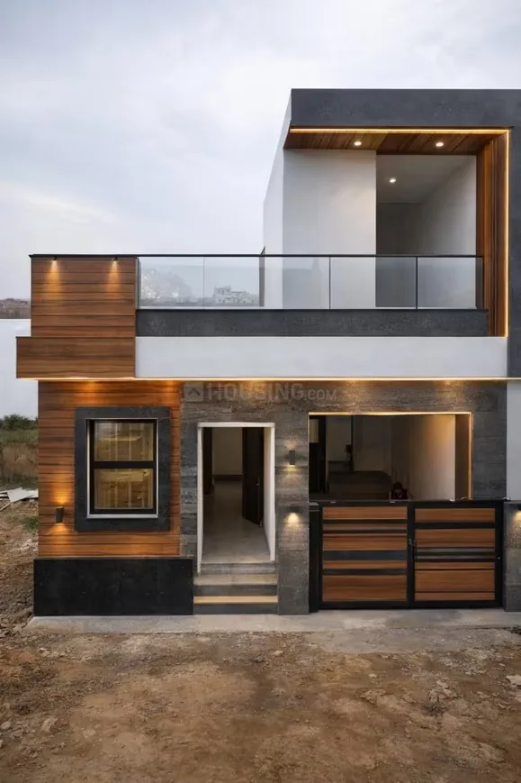 Mudgal Ved Enclave — Modern residential villa with wooden facade, glass balcony railing, and stylish gate under a cloudy sky.